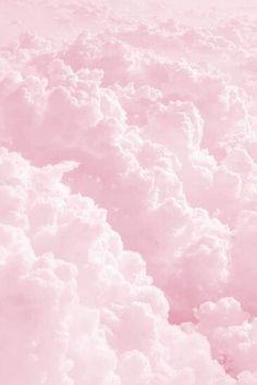 the sky is filled with fluffy clouds in pink and white colors, as seen from an airplane