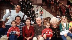 a family posing for a photo in front of christmas tree