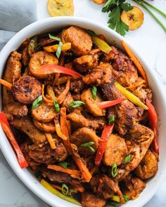 a white bowl filled with chicken and carrots on top of a marble countertop