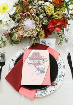 the table is set with flowers and place settings