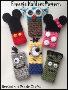 six crocheted cell phones are arranged in a row, with eyes and noses on them