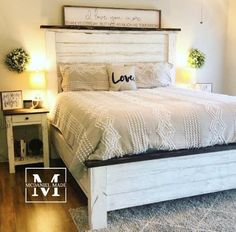 a white bed sitting on top of a wooden floor next to two lamps and a night stand