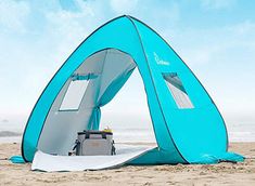 a blue tent sitting on top of a sandy beach