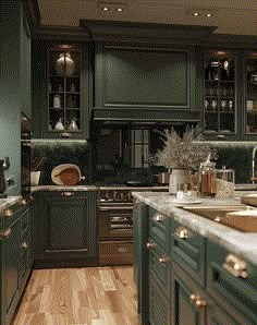 a kitchen filled with lots of green cabinets and counter top space next to a wooden floor