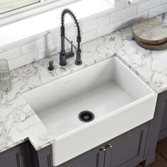 a white kitchen sink sitting under a window