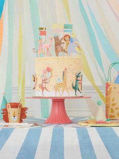 there is a cake with animals on it and other decorations around the cake, as well as an animal figurine