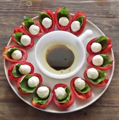 a white plate topped with mini bell peppers covered in mozzarella and olive oil