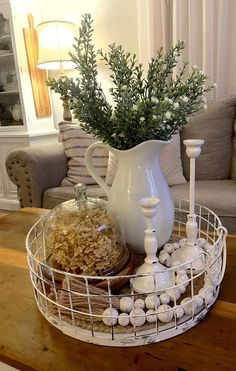 a white pitcher sitting on top of a table next to a basket filled with food