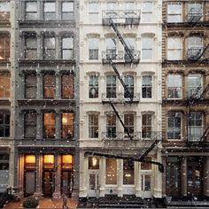 an apartment building is covered in snow as it sits next to other buildings and fire escapes