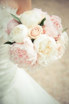 a bride holding a bouquet of pink and white flowers on her wedding day in france