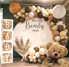 a teddy bear sitting in front of a backdrop for a baby's first birthday