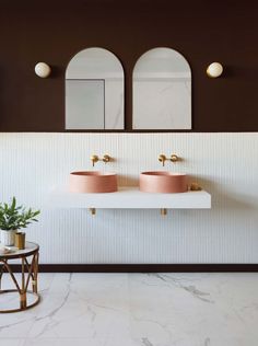 two sinks in a bathroom with mirrors above them