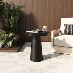 a black table sitting on top of a white floor next to a chair and potted plant