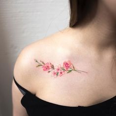 a woman with a tattoo on her shoulder and pink flowers in the upper part of her left arm