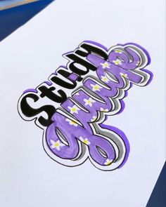 the word sticker is on top of a white paper with purple and black lettering