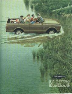 an old car driving through water with people in the back seat and on the front