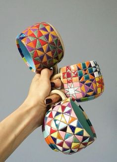 someone is holding some colorful shoes in their hand and they are all made out of different colors