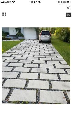 a car parked in front of a house on a driveway made out of pavers