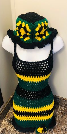 a mannequin wearing a crocheted hat with yellow and black trims