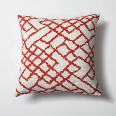 a red and white pillow on a white wall