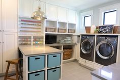 a washer and dryer sitting in a room next to each other on top of cabinets