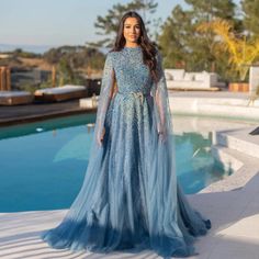 Erleben Sie die ultimative Eleganz und Raffinesse mit unserem Dreamy Vow Luxury Dubai Blue Arabic Abendkleid. Dieses Kleid mit wunderschönen Cape-Ärmeln und hohem Kragen zeigt die perfekte Mischung aus modernem und traditionellem Stil. Perfekt für jeden besonderen Anlass – seien Sie in diesem atemberaubenden Kleid der Star der Nacht. Arabic Dress Modern, Blue Gowns Elegant, Arabic Dress Modern Beautiful, Yellow Evening Dresses, Grey Evening Dresses, Champagne Evening Dress, Gold Evening Dresses, Green Evening Dress, Pink Evening Dress