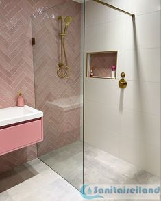 a bathroom with pink and gold fixtures in the shower, sink, and bathtub