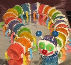 there is a cake decorated to look like a caterpillar with many colors on it