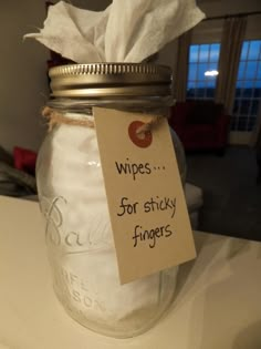 a glass jar with a label on it that says wipes for sticky fingers