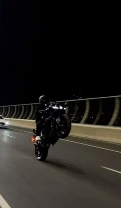 a man riding a motorcycle down a highway at night