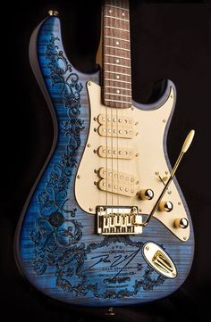 an electric guitar with blue and white paint on it's body, in front of a black background