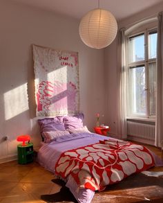 a bedroom with a large bed and two windows