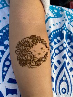 a woman's arm with a henna tattoo on her left arm and the moon in the middle