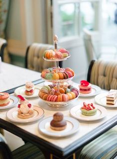 a table topped with plates filled with different types of cakes and desserts on top of it