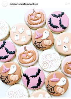 some decorated cookies are sitting on a white table and one is pink, the other is black