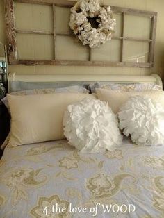 a bed with two pillows on it and a wreath above the headboard behind them