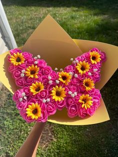 a bouquet of pink and yellow flowers in a cardboard box