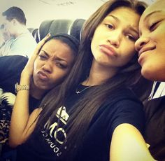 three young women sitting next to each other on a couch with their faces close together