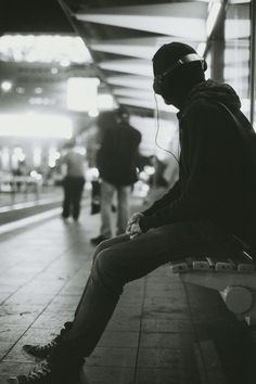 a man sitting on a bench with headphones in his ears