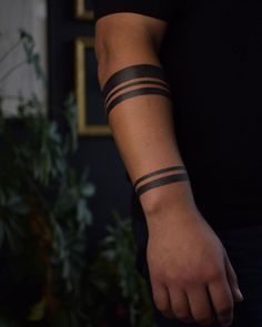 a person with a black wrist tattoo on their arm