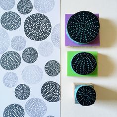 three rubber stamps with circles on them next to a piece of paper that has been cut out