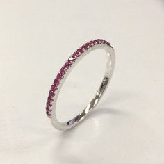 a white gold ring with pink sapphire stones