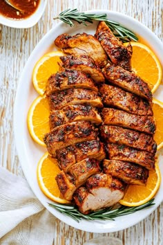 sliced chicken and orange slices on a white plate