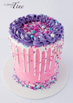 a pink and purple cake with sprinkles on it