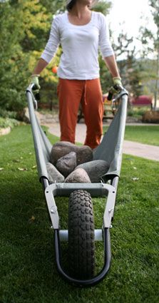 a woman standing on top of a wheel barrow