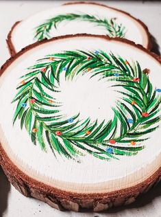 two pieces of wood are decorated with green and red designs on them, one has a pine tree branch in the center