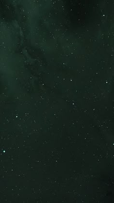 the night sky is filled with stars and dark green hues, as well as white clouds