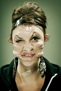 a woman with her face painted to look like she is holding scissors in front of her mouth