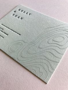 a close up of a business card on top of a white surface with an abstract design