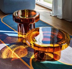 two glass tables sitting on top of a rug